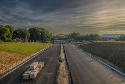 Empty road against sky during sunset