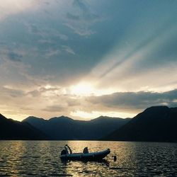 Boat sailing in sea at sunset