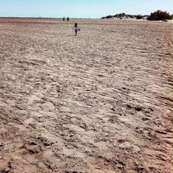 Low section of person walking on sand at beach