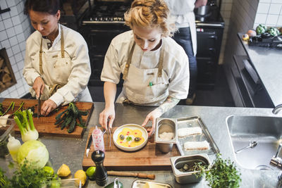 High angle view of female chefs working at kitchen counter in restaurant