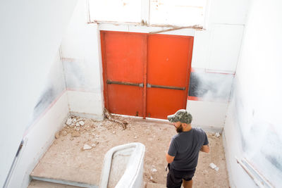 Rear view of man standing against wall