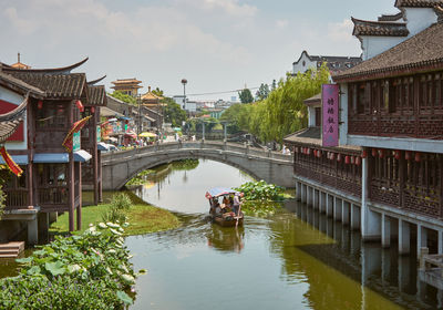 Footbridge over canal amidst buildings in city