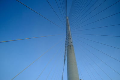 Low angle view of suspension bridge against clear blue sky