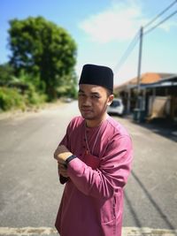 Portrait of young man standing on road