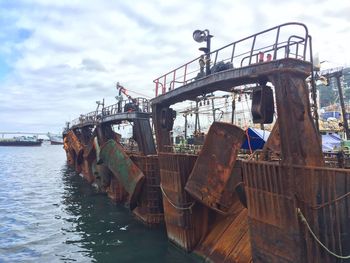 Ship moored in water against sky