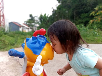 Rear view of girl with toy on land