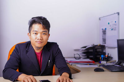 Portrait of young man sitting at table