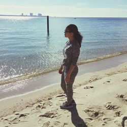 Full length of boy standing on beach against sky