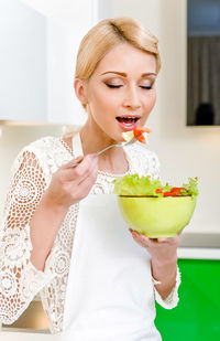 Young woman eating food at home