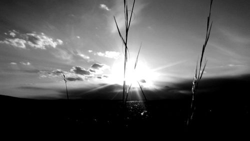 Silhouette landscape against sky on sunny day