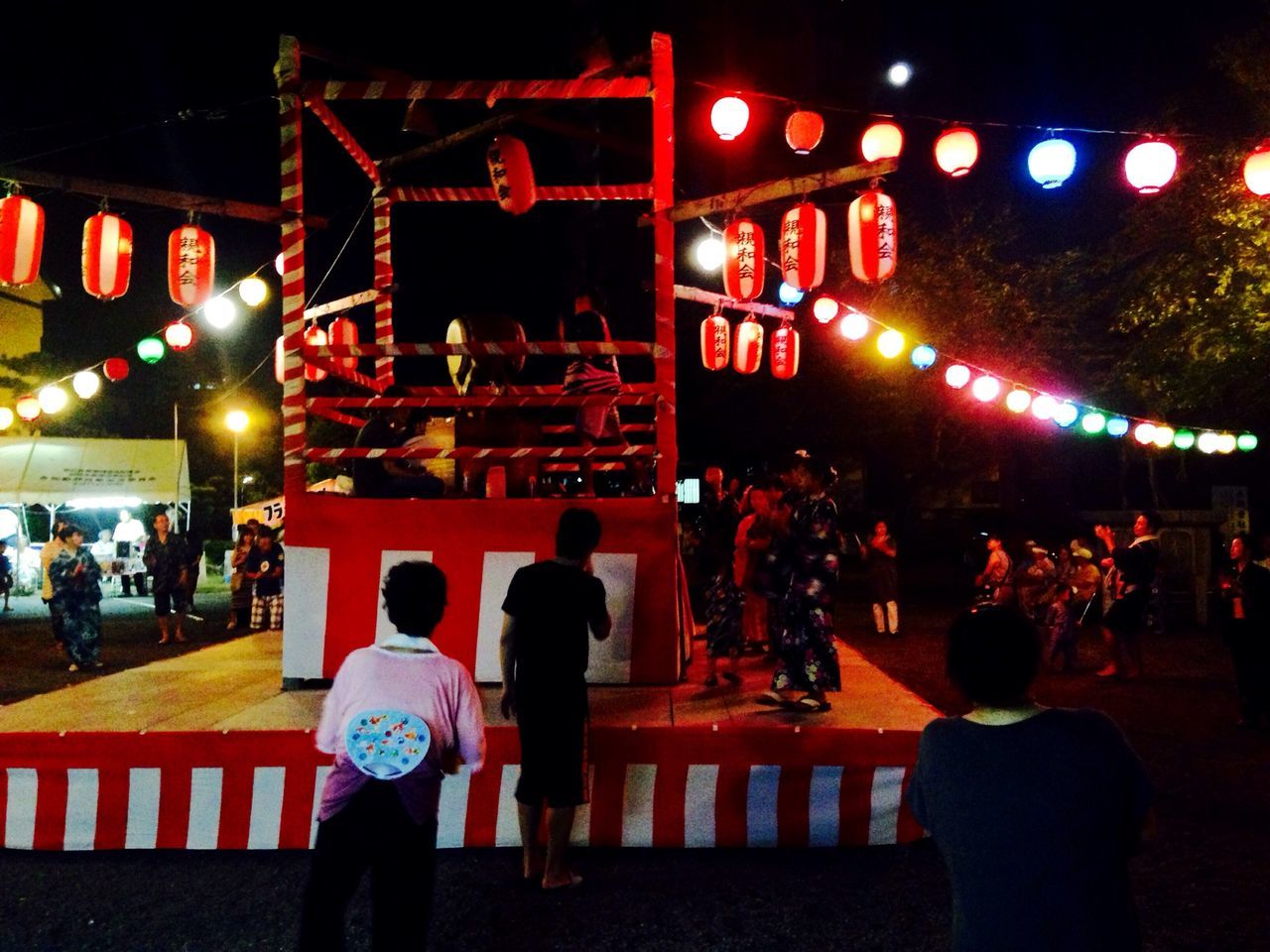 illuminated, night, lifestyles, men, person, leisure activity, lighting equipment, celebration, large group of people, red, standing, rear view, street, lantern, tradition, outdoors, city, togetherness, city life