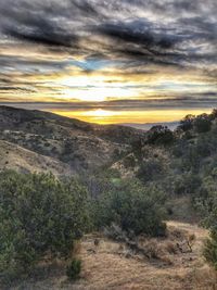 Scenic view of land against sky during sunset