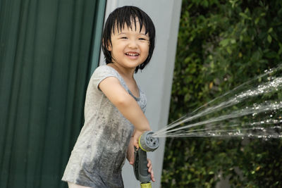 Full length of smiling woman holding while standing outdoors