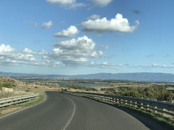 Empty road along landscape against sky