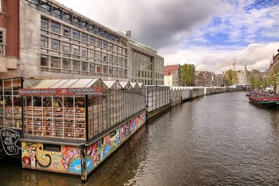 Bridge over river amidst buildings against sky