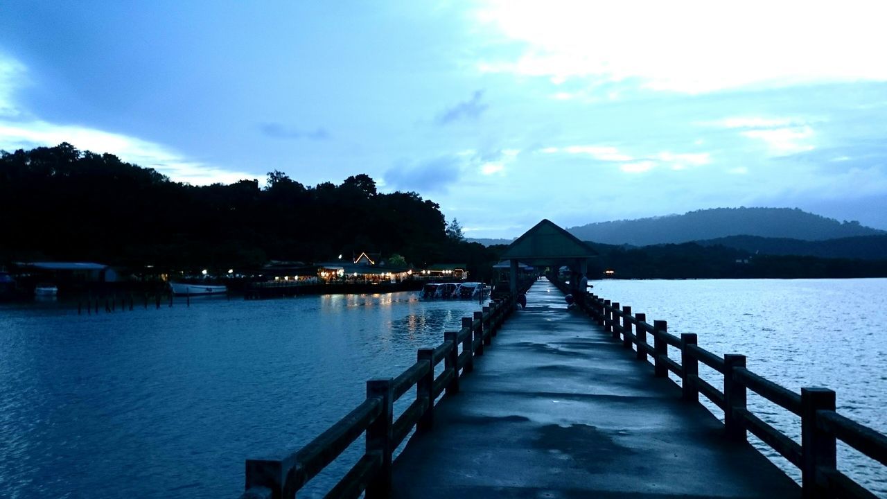 VIEW OF PIER OVER CALM SEA AGAINST SKY