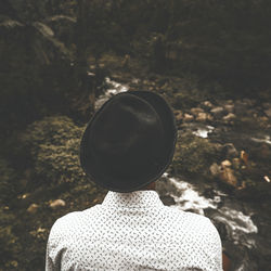 Rear view of man wearing hat at forest