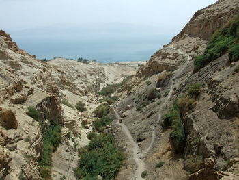 Scenic view of rocky mountains and sea against sky