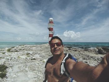 Portrait of mature man on beach against sky