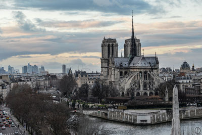 Panoramic view of buildings against cloudy sky