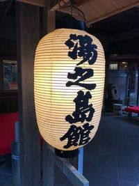 Close-up of illuminated lantern on restaurant at night