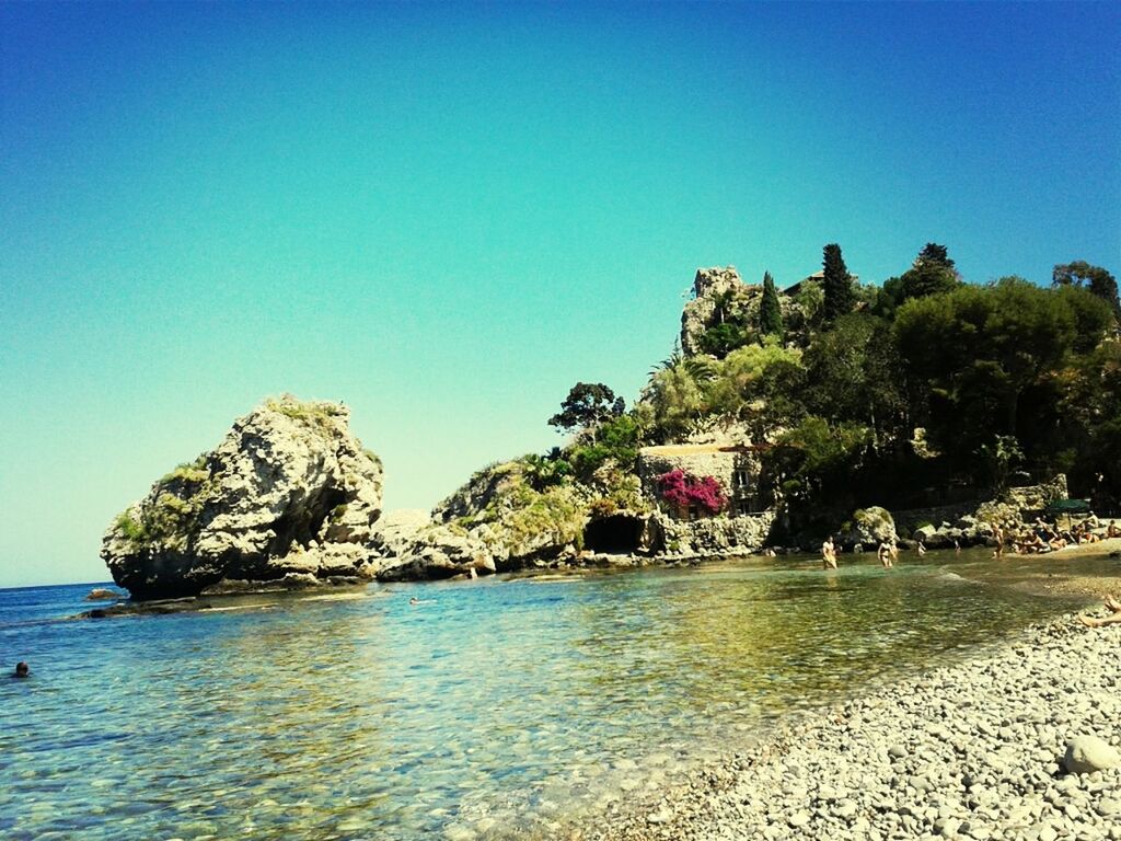 clear sky, sea, water, copy space, blue, rock formation, beach, tranquility, tranquil scene, rock - object, cliff, scenics, beauty in nature, nature, nautical vessel, horizon over water, shore, tree, transportation, coastline