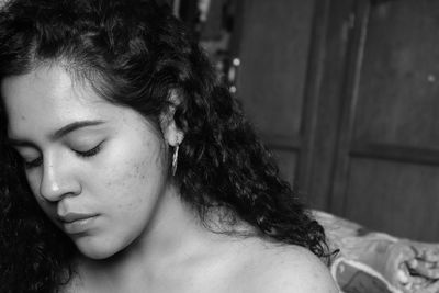 Close-up of young woman with eyes closed sitting at home