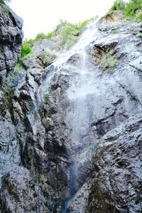 Low angle view of waterfall against sky