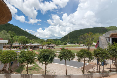 Trees and buildings in town against sky