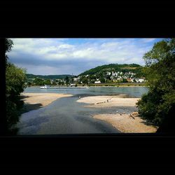 Scenic view of beach against cloudy sky