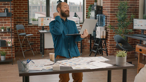 Smiling businessman working on laptop at office