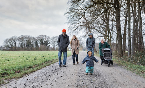 Family walking on dirt road during winter