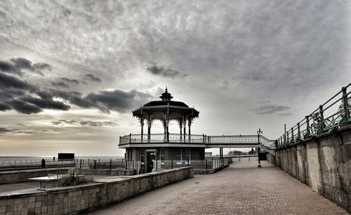 Pier on sea against cloudy sky