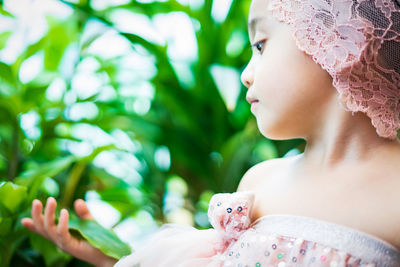 Close-up of cute girl touching plant