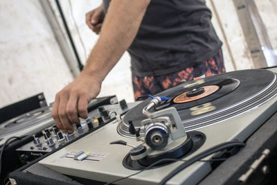 Midsection of man working a dj at a festival including close-up of a dj deck