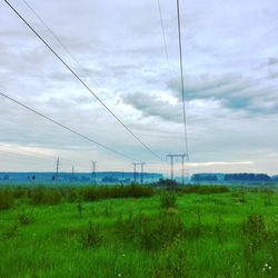 Electricity pylon on field against sky