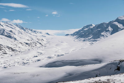 Scenic view of snow covered mountains against sky