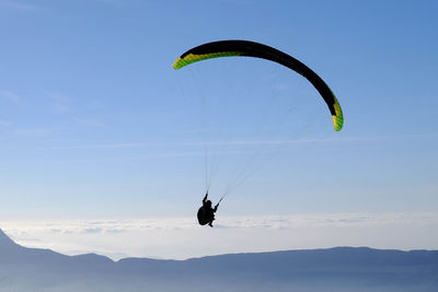 Person paragliding in sky