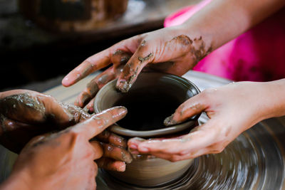 Cropped hands making clay pot