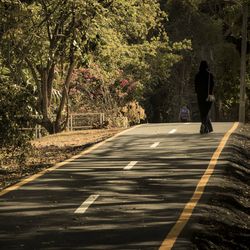 Rear view of woman walking on road