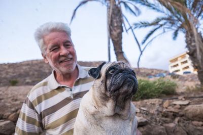 Senior man holding pug