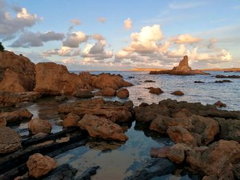 Rocks on sea shore against sky