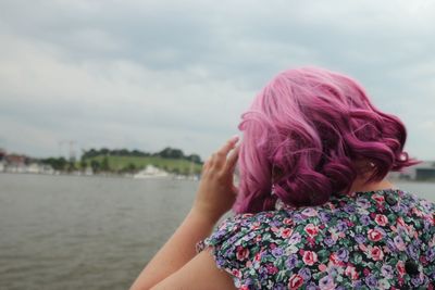 Rear view of woman with dyed hair by river