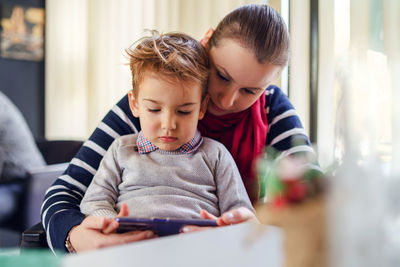 Boy and woman using mobile phone