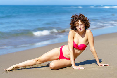 Portrait of young woman sitting on beach