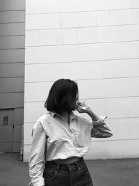 Full length of woman standing against wall