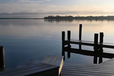 Pier on lake against sky during sunset