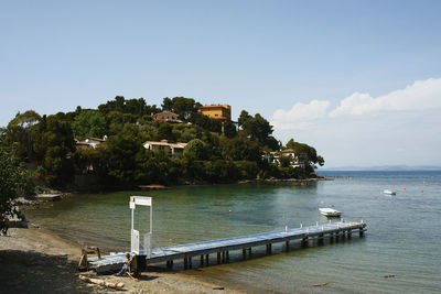 Scenic view of sea by buildings against sky