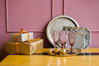 Pink glass glasses, gift boxes, christmas tree wreath, metal trays in the pink kitchen. christmas