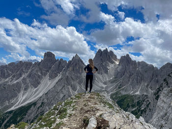 Rear view of man walking on mountain against sky